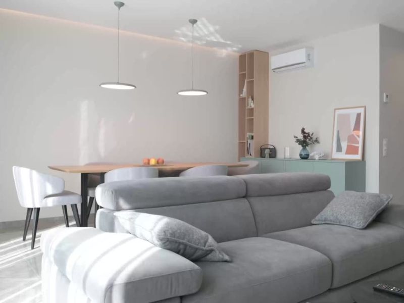 Dnevni boravak u apartmanu, veliki sto za ručavanje sa stolicama i siva ugaona