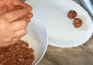 žena mokrim rukama vadi meso iz činije i oblikuje u ćufte, ređa na beli tanjir