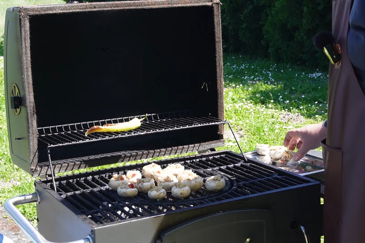 osoba peče pečurke sa sirom na roštilju